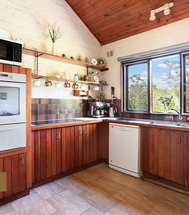 A kitchen featuring wooden cabinets and a window, creating a warm and inviting atmosphere.