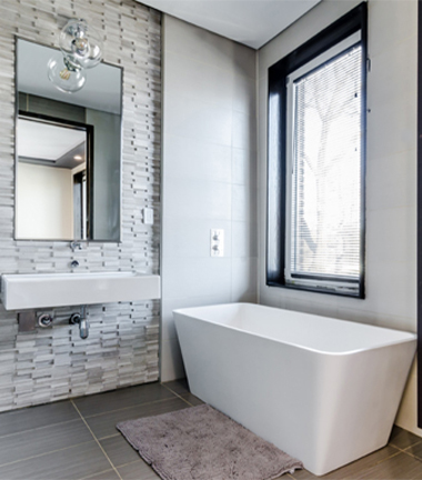 Modern bathroom featuring a large tub and a window, creating a bright and spacious atmosphere.