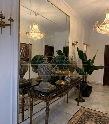 Modern room with mirror and vase on table.